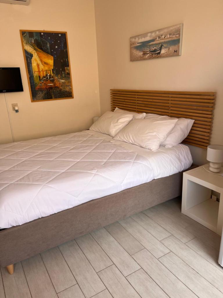 une chambre avec un grand lit avec des draps blancs dans l'établissement Ashur mondello, à Palerme 28 autres photos