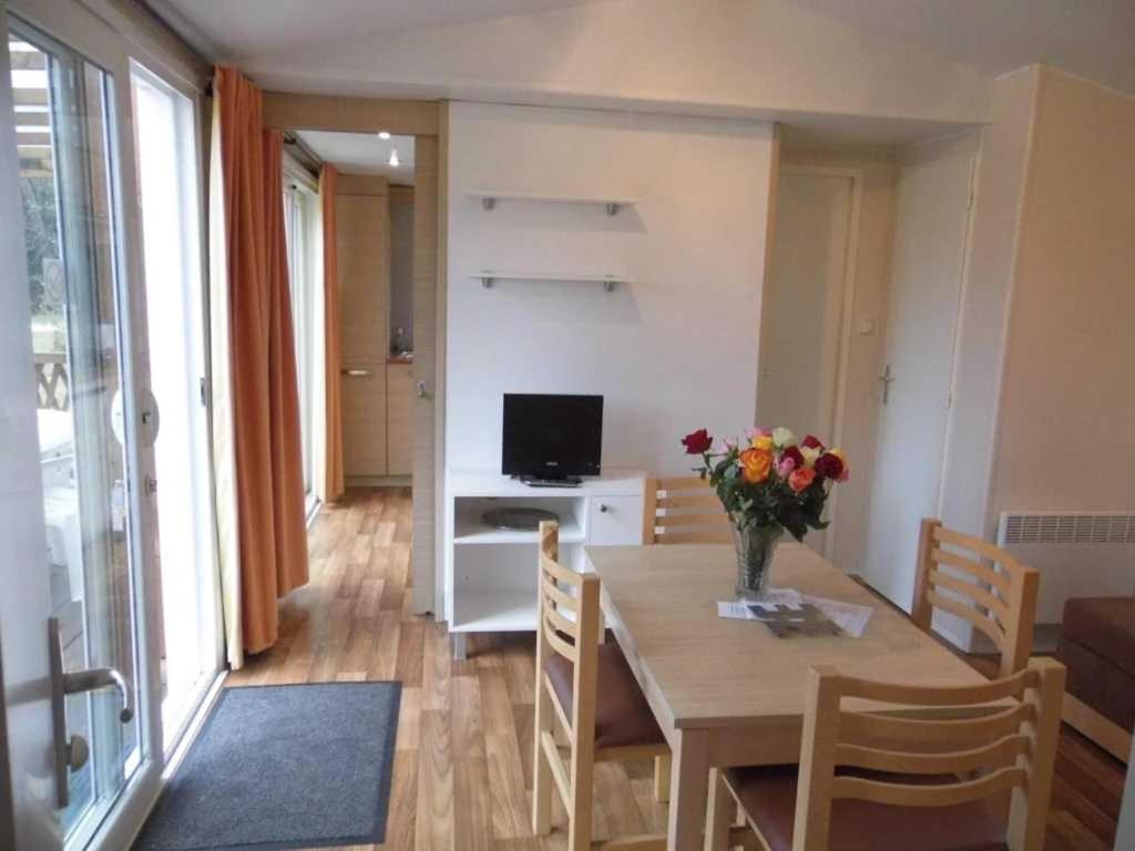 un salon avec une table avec un vase de fleurs dans l'établissement Chalet 3 étoiles - Piscine - ccafgfe, à Douville