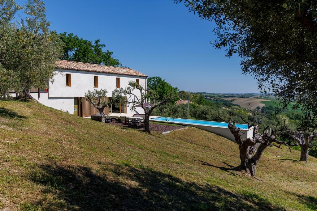 une maison sur une colline avec un bateau dessus dans l'établissement Luxury Retreat - piscina da sogno, à Cingoli