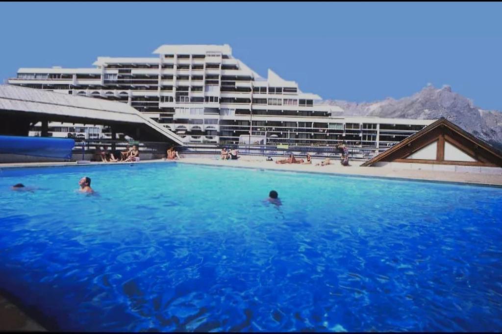 - une grande piscine avec des personnes dans un grand bâtiment dans l'établissement Enjoy, à Puy-Saint-Vincent