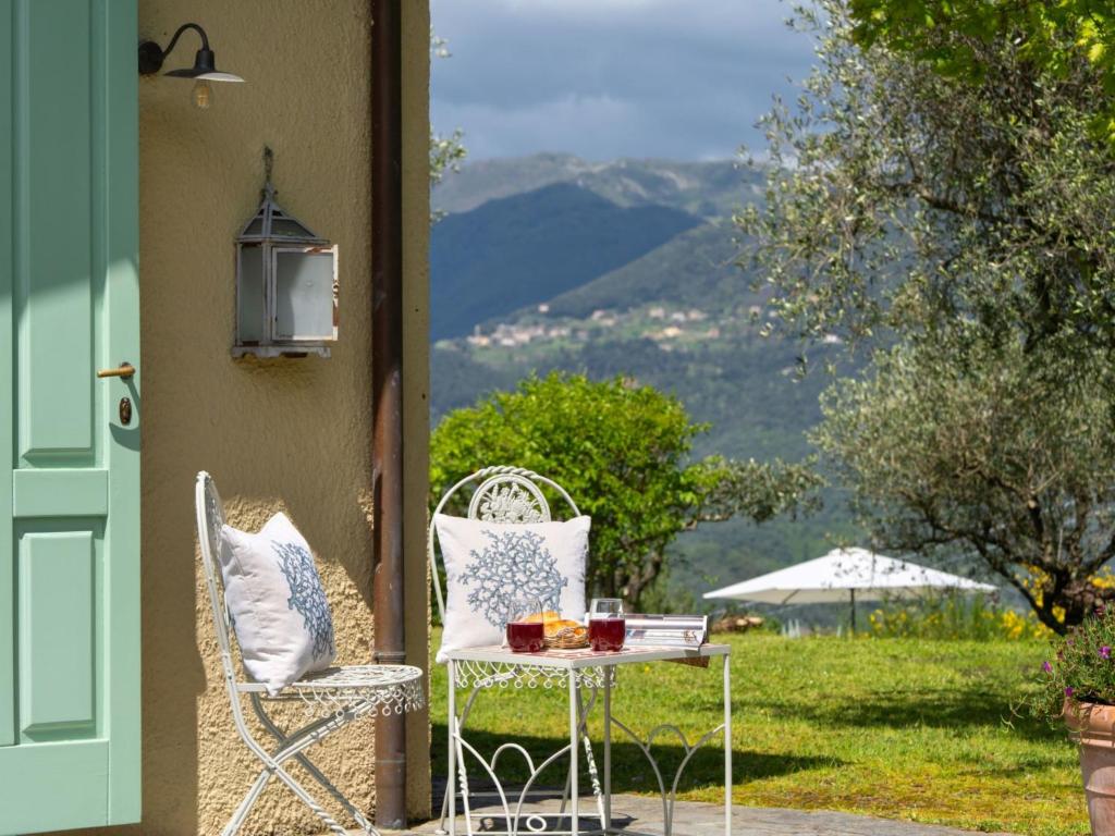 une table et des chaises assises sur une terrasse couverte avec une table et une table dans l'établissement Villa Monica by Interhome, à Mommio