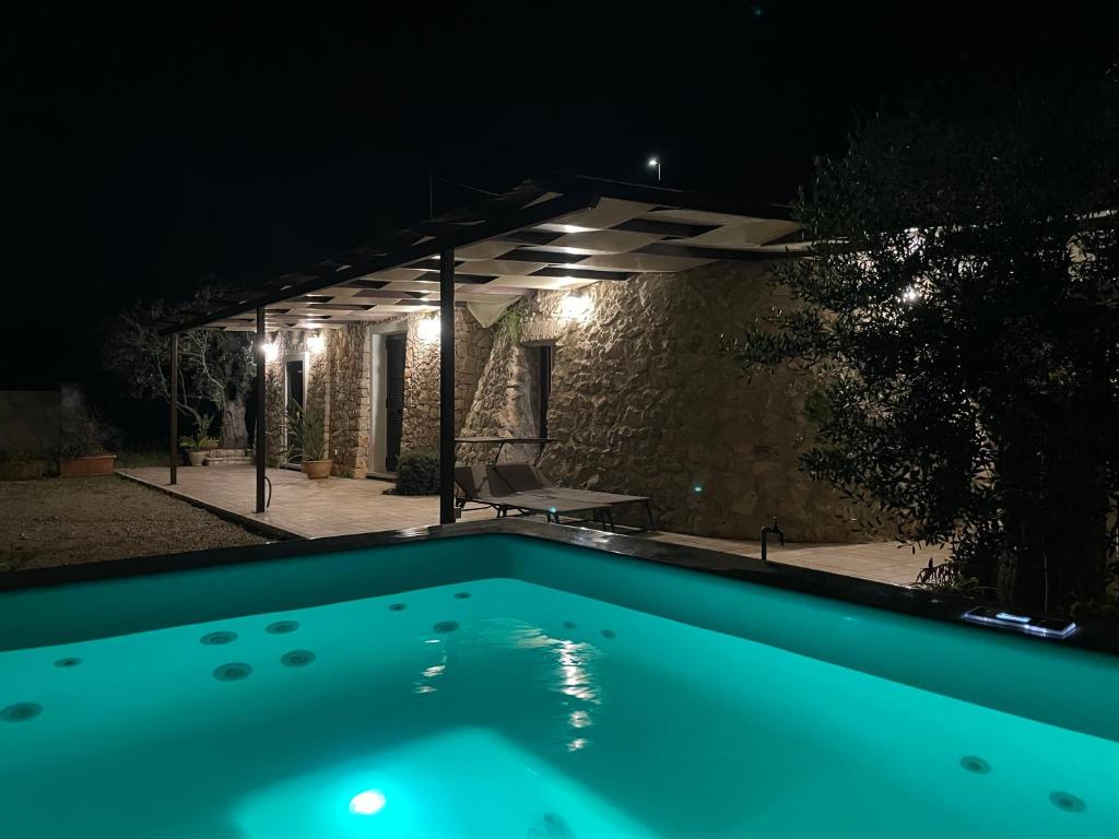 une piscine dans un jardin la nuit dans l'établissement Trullo vista mare con idromassaggio, à Marina San Gregorio