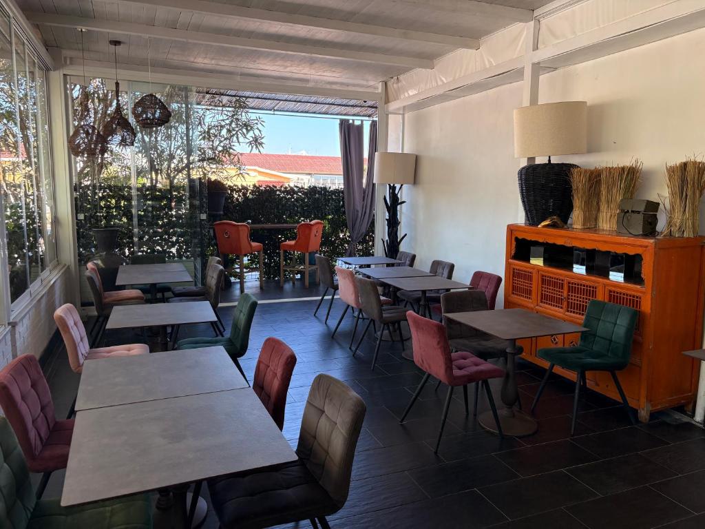 un restaurant avec des tables et des chaises et une fenêtre dans l'établissement Hotel Atlantic, à Marina di Carrara