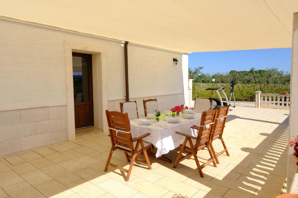 une table blanche et des chaises sur une terrasse dans l'établissement Tenuta con due abitazioni indipendenti, à Martina Franca