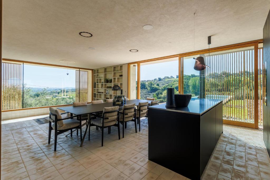 - une salle à manger avec une table, des chaises et de grandes fenêtres dans l'établissement Luxury Retreat - piscina da sogno, à Cingoli