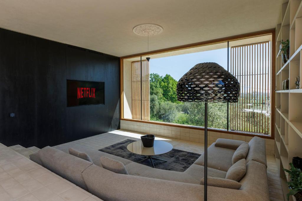 un salon avec un canapé et une grande fenêtre dans l'établissement Luxury Retreat - piscina da sogno, à Cingoli