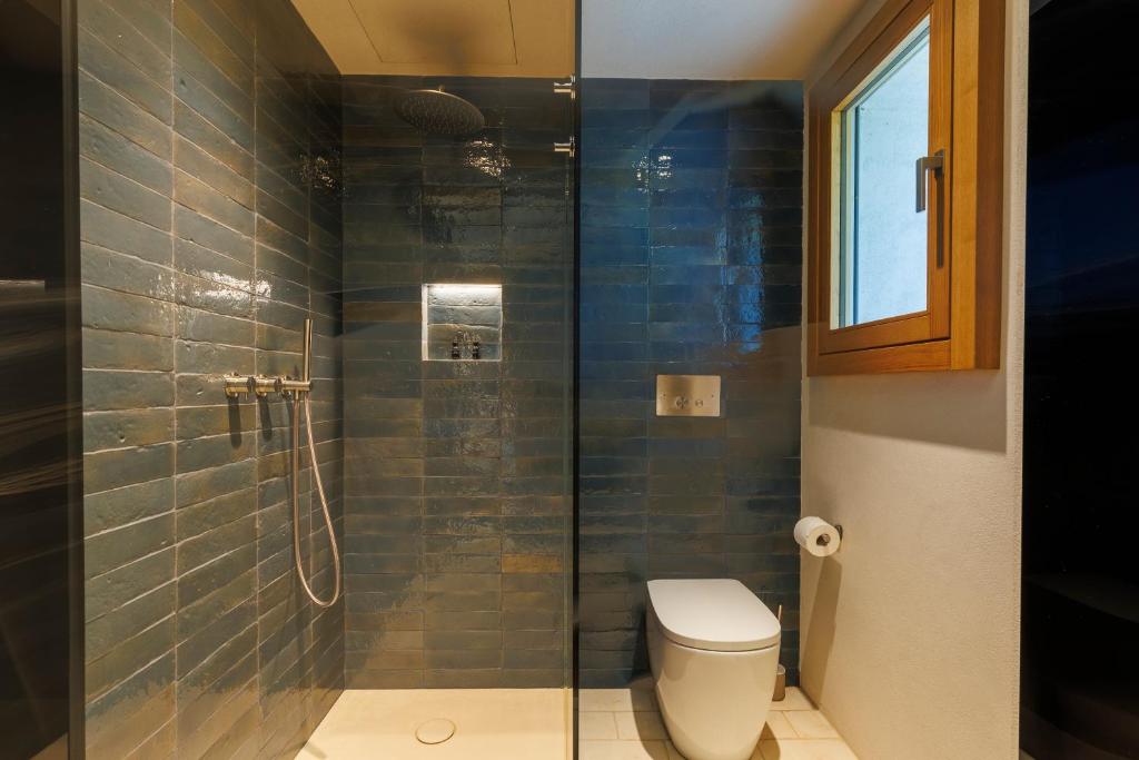 une salle de bain avec toilettes et douche en verre dans l'établissement Luxury Retreat - piscina da sogno, à Cingoli