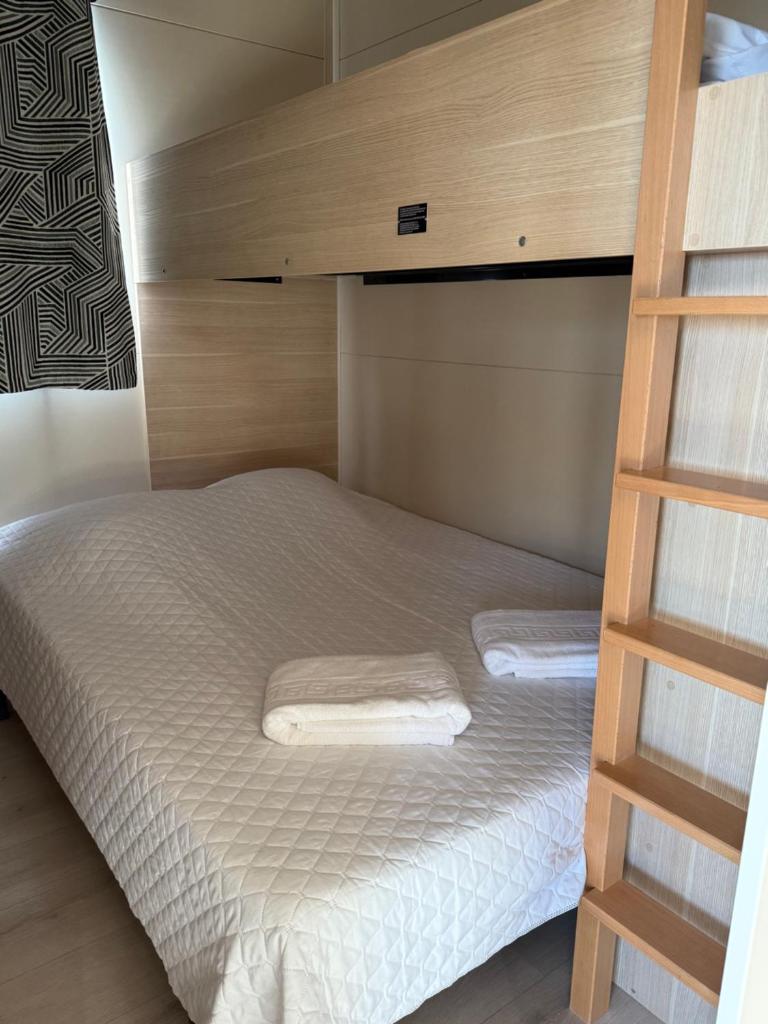 - une chambre avec des lits superposés et 2 serviettes blanches dans l'établissement Mobile-home magnifique vue mer camping 4 etoiles, à Saint-Raphaël