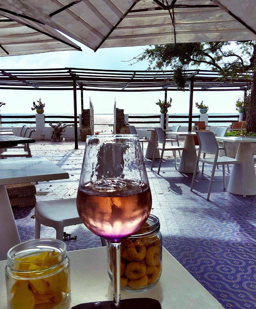 un verre de vin assis au-dessus d'une table dans l'établissement Hotel e Residence Il Faro Acciaroli, à Acciaroli