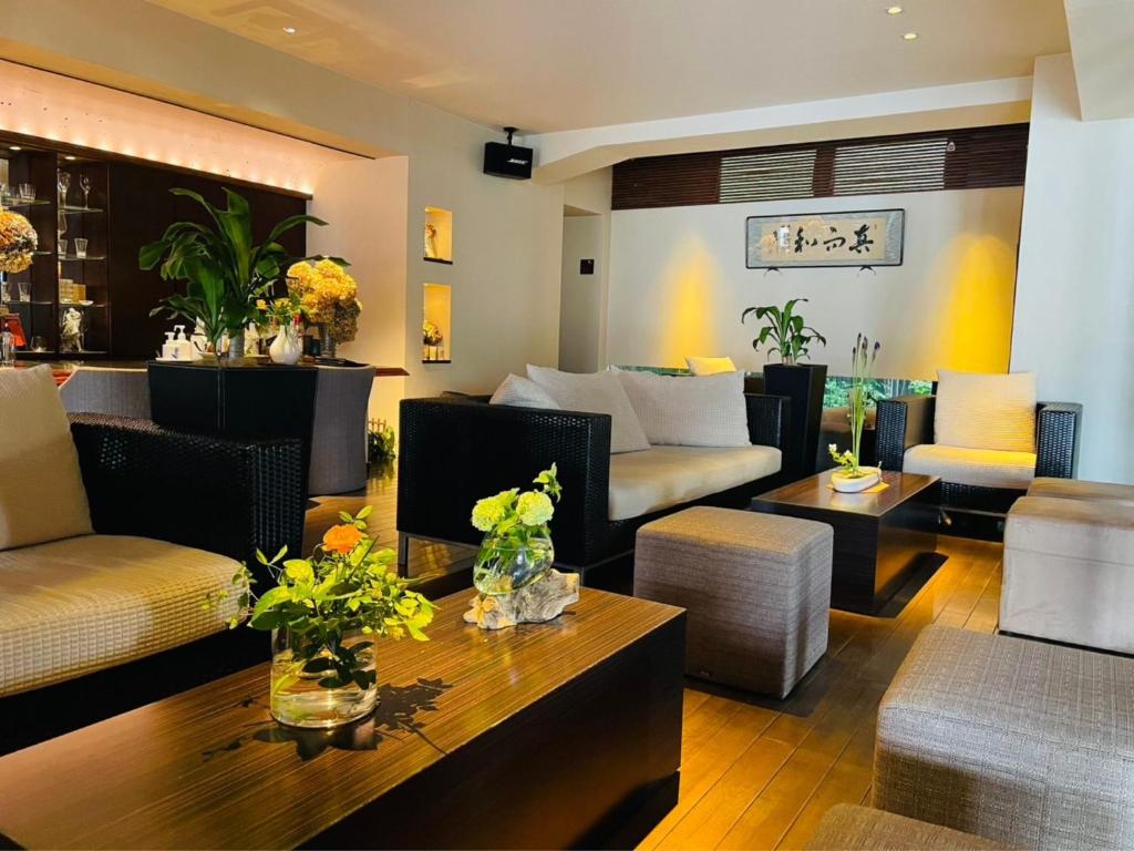 un salon avec un canapé, des chaises et une table dans l'établissement Ryotei Matsuya Honkan Suizenji, à Kumamoto