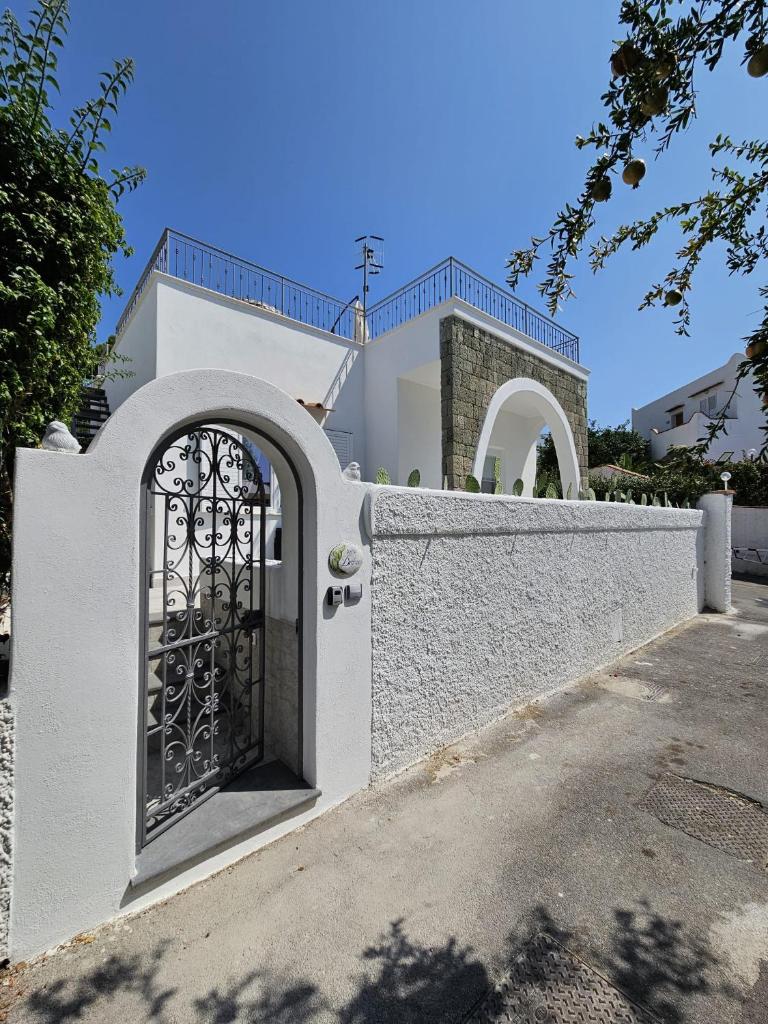 une clôture blanche avec un portail devant une maison dans l'établissement Villa Dafne, à Ischia