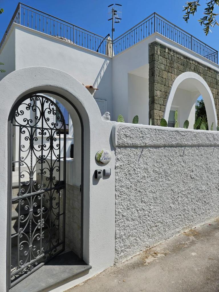une maison blanche avec un portail et un mur dans l'établissement Villa Dafne, à Ischia