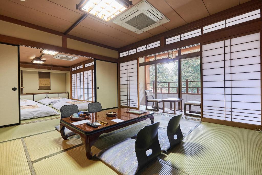 une chambre avec un lit, une table et des chaises dans l'établissement Ryokan Koyokan, à Yasugi