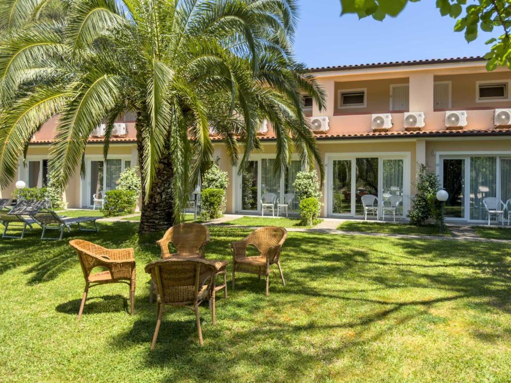un groupe de chaises et une table devant une maison dans l'établissement Hotel Villa Rodriguez, à Capoliveri