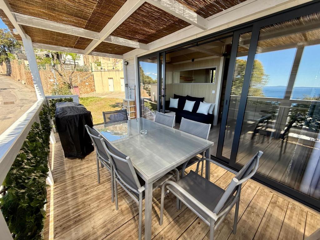 un patio avec une table et des chaises sur une terrasse dans l'établissement Mobile-home magnifique vue mer camping 4 etoiles, à Saint-Raphaël 8 autres photos