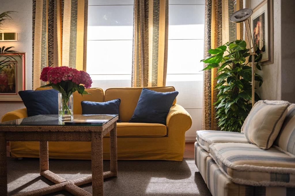 un salon avec un canapé jaune et une table dans l'établissement Park Hotel Maracaibo, à Lido di Jesolo