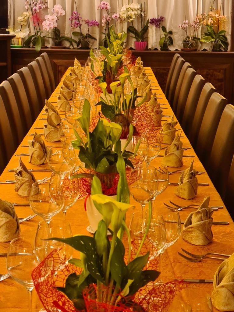 une longue table avec des verres à vin et des fleurs dessus dans l'établissement Hotel Nautilus, à Nicotera Marina