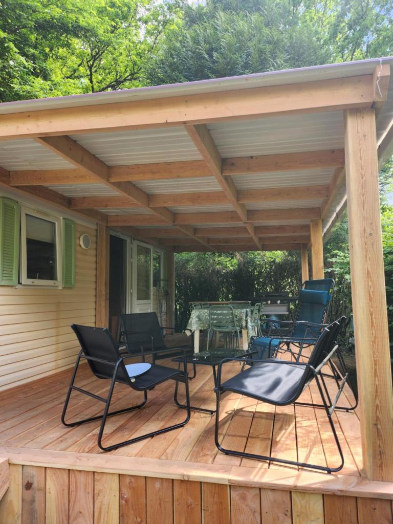 un patio avec des chaises et une table sur une terrasse dans l'établissement Mobilhome les pieds dans l eau avec piscine, à Saint-Gérons