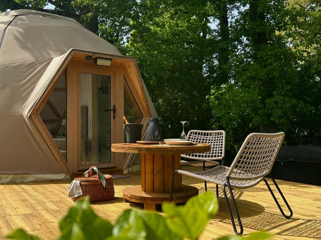 une tente avec deux chaises et une table en face de celle-ci dans l'établissement Dôme Pathome, à Catonvielle