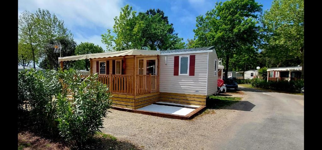 une petite maison assise sur le côté d'une rue dans l'établissement Mobil Home Camping Les VIVIERS, Claouey, à Claouey