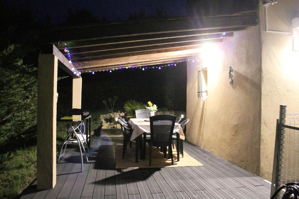 - un patio avec une table et des chaises sur une terrasse la nuit dans l'établissement Gîte Les Amandiers, à Villedubert