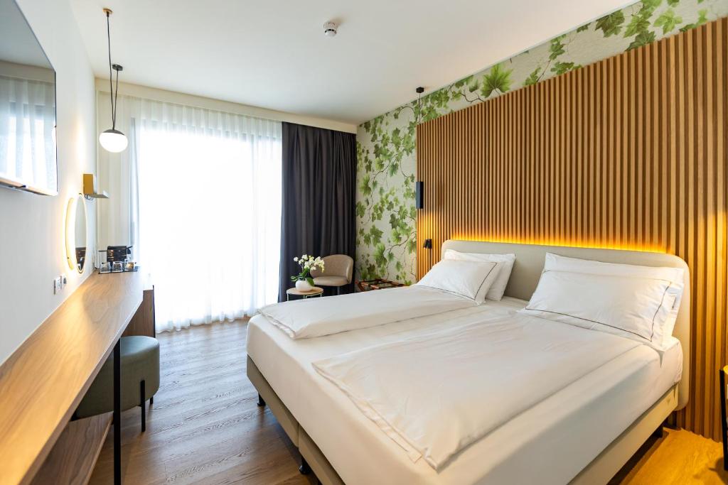 une chambre avec un grand lit blanc dans une pièce dans l'établissement Hotel Europa, à Sirmione