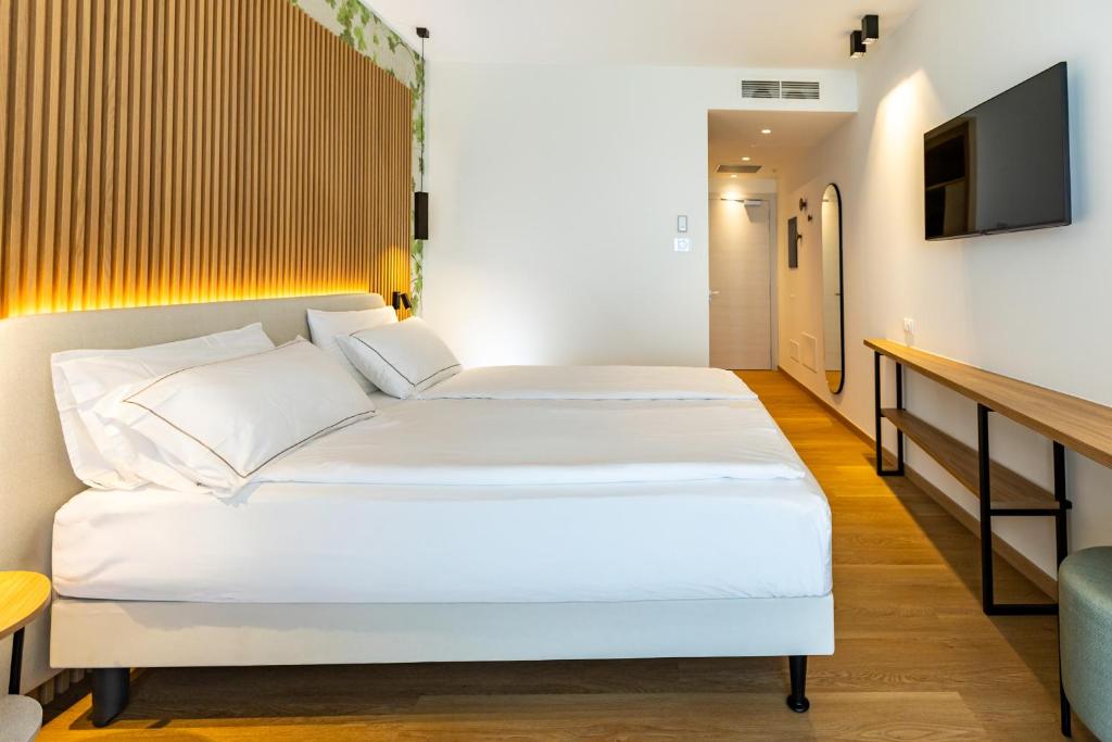 une chambre d'hôtel avec deux lits et une télévision dans l'établissement Hotel Europa, à Sirmione