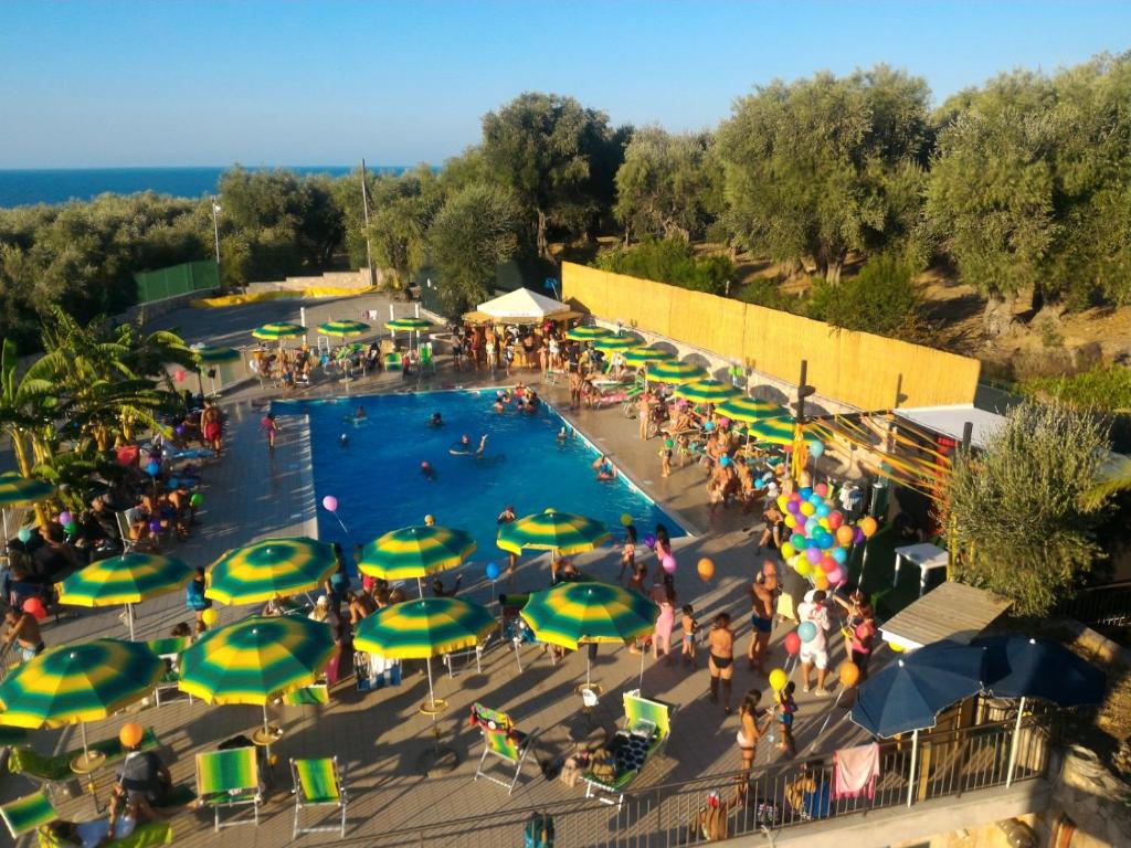 une vue aérienne d'une piscine avec des gens et des parasols dans l'établissement Ibisco Hotel, à Rodi Garganico