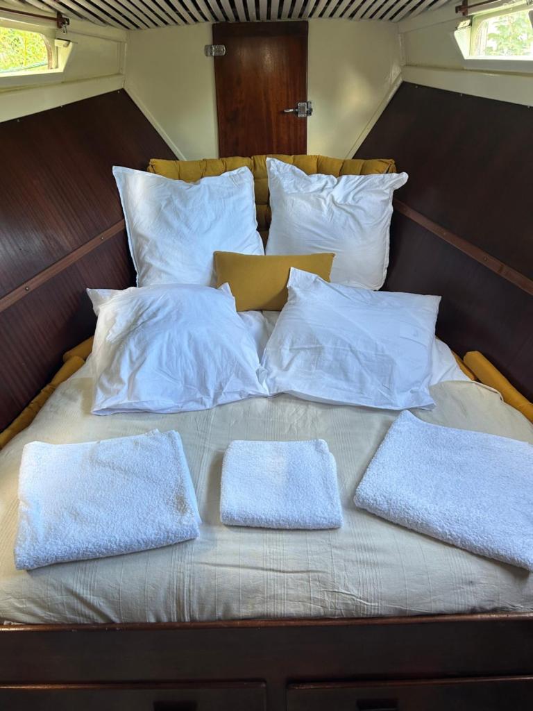 - un lit avec des oreillers blancs dans l'établissement Séjour insolite sur un bateau, à Louveciennes