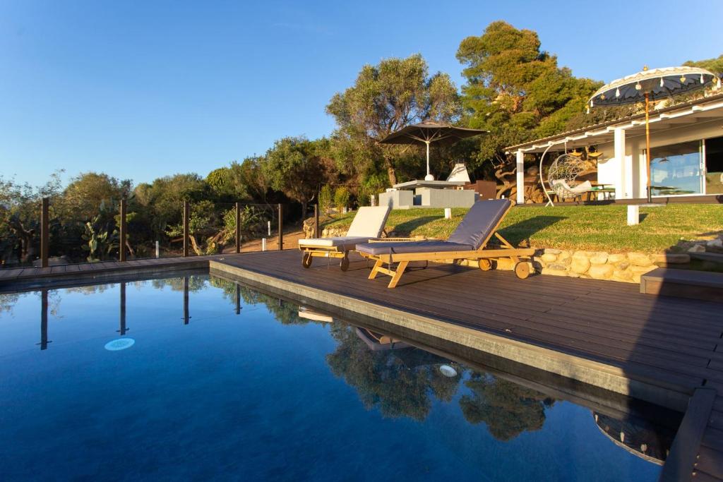 - une piscine avec un fauteuil à côté d'une maison dans l'établissement Villa Gaia, à Quartu Sant'Elena