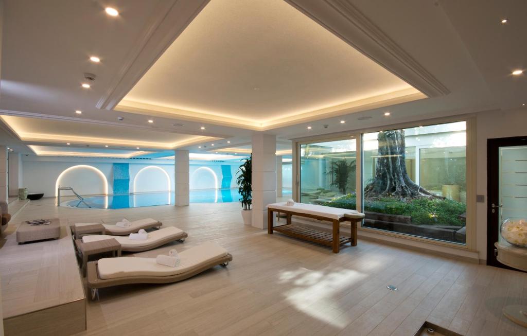 un salon avec des tables et une grande fenêtre dans l'établissement Grand Hotel Da Vinci, à Cesenatico