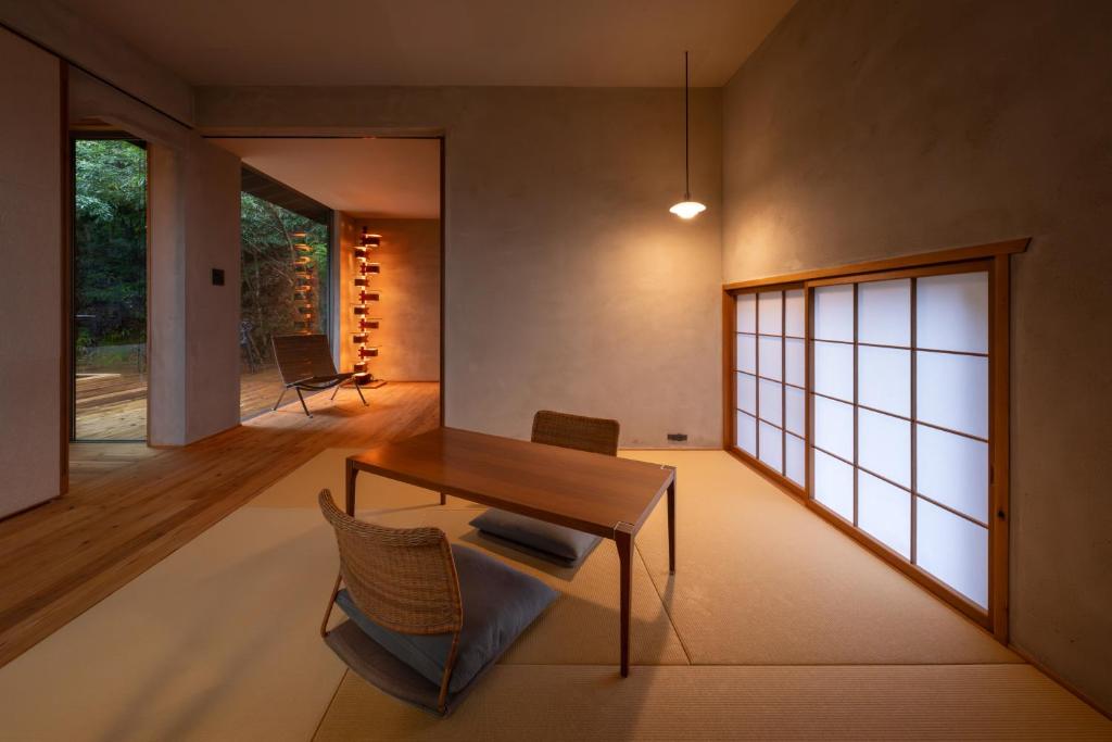 un salon avec une table et des chaises en bois dans l'établissement 奥武雄温泉　風の森, à Ureshino
