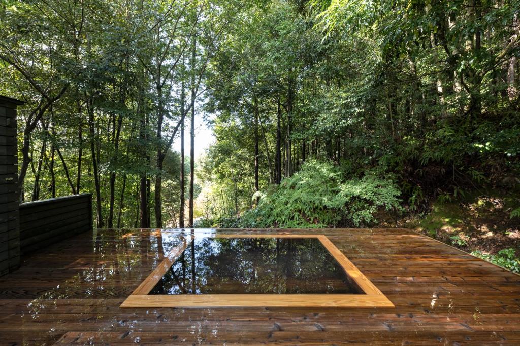 un étang au milieu d'une terrasse en bois dans l'établissement 奥武雄温泉　風の森, à Ureshino