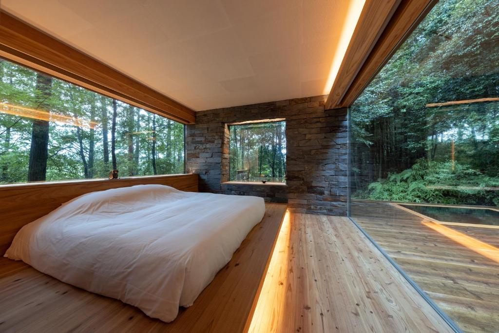 - une chambre dans une cabane dans les arbres avec une grande fenêtre dans l'établissement 奥武雄温泉　風の森, à Ureshino