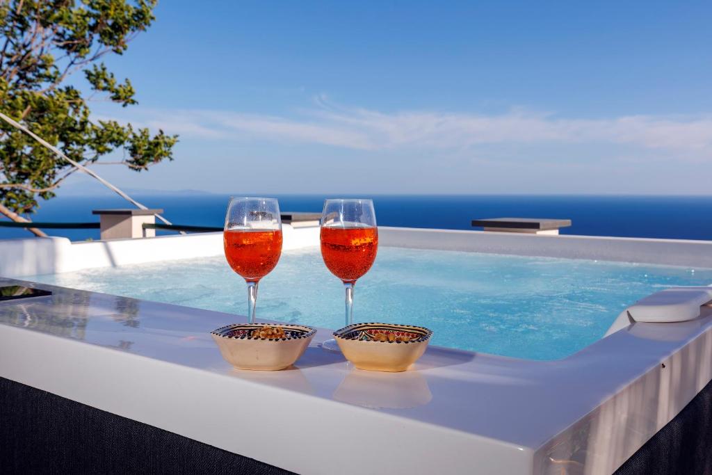- deux verres de vin assis au-dessus de la piscine dans l'établissement Villa Le Porpore, à Furore