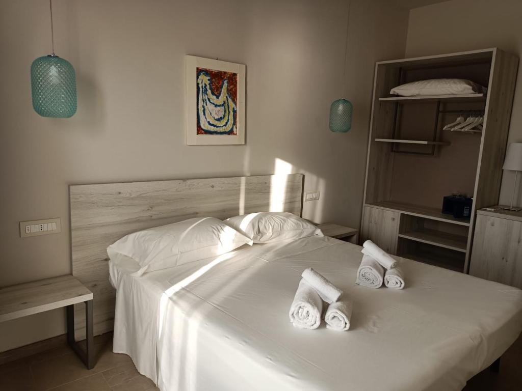 une chambre avec un lit blanc avec des serviettes dessus dans l'établissement Borgo di Riaci Beach Resort, à Santa Domenica