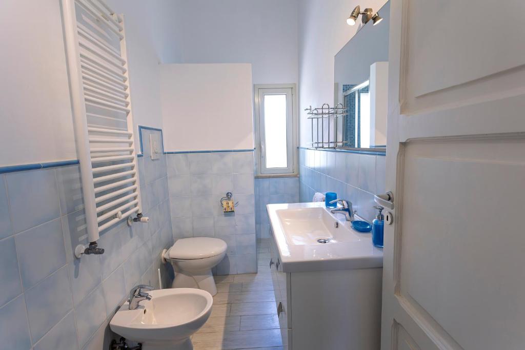 une salle de bain blanche avec un lavabo et des toilettes dans l'établissement Villanna - Villa con piscina & splendido giardino, à Alimini