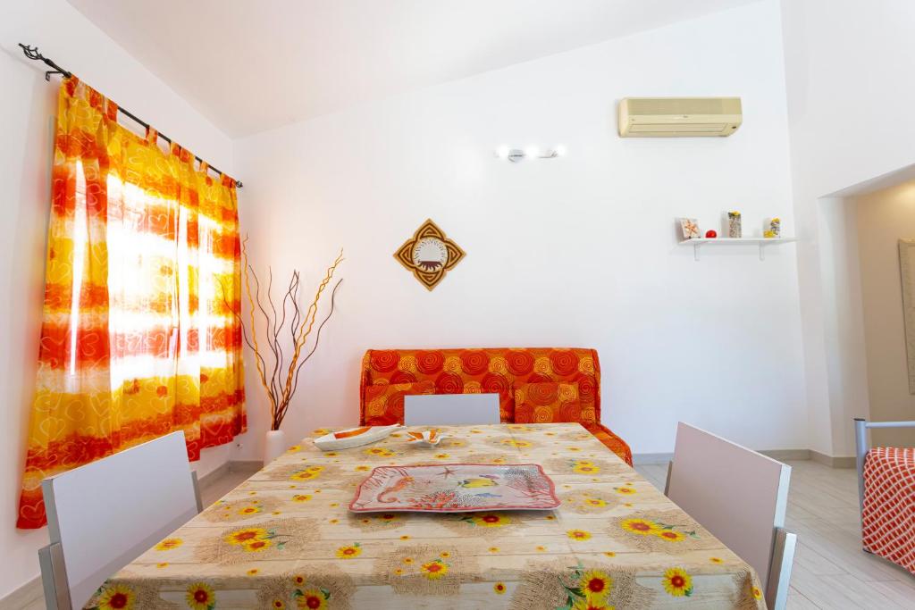 une salle à manger avec une table et une table et des chaises dans l'établissement Villanna - Villa con piscina & splendido giardino, à Alimini