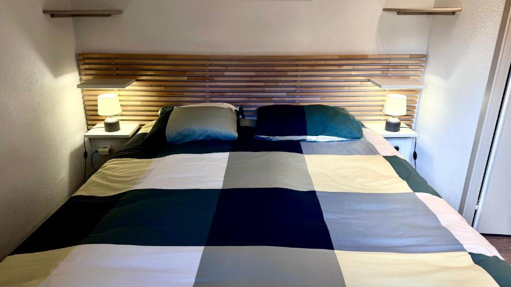 une chambre avec un lit avec deux lampes sur deux tables dans l'établissement Aux portes du parc national de la Vanoise Appartement Termignon Val Cenis avec Wifi, à Termignon