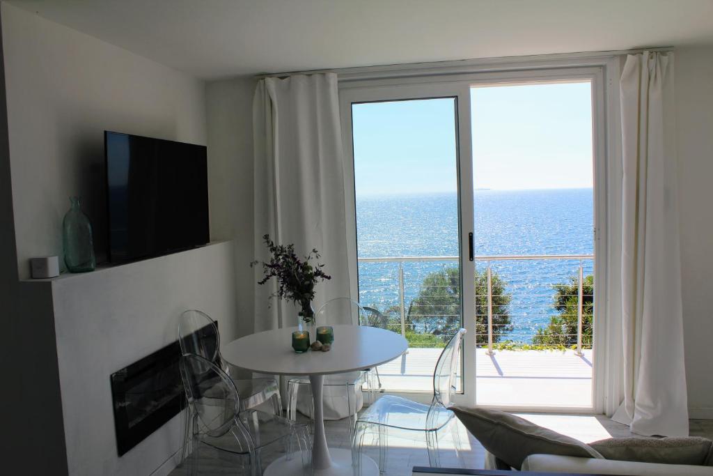 un salon avec une table et une grande fenêtre dans l'établissement Conca Verde c21- BEACH FRONT little villas POOL, private JACUZZI sea view, à Marina dʼAndora