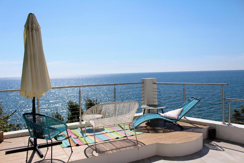 - deux chaises et un parasol sur le balcon donnant sur l'océan dans l'établissement Conca Verde c21- BEACH FRONT little villas POOL, private JACUZZI sea view, à Marina dʼAndora
