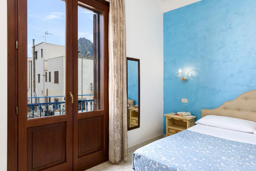 - une chambre avec un lit et une porte avec un balcon dans l'établissement Araba Fenice Hotel, à San Vito Lo Capo