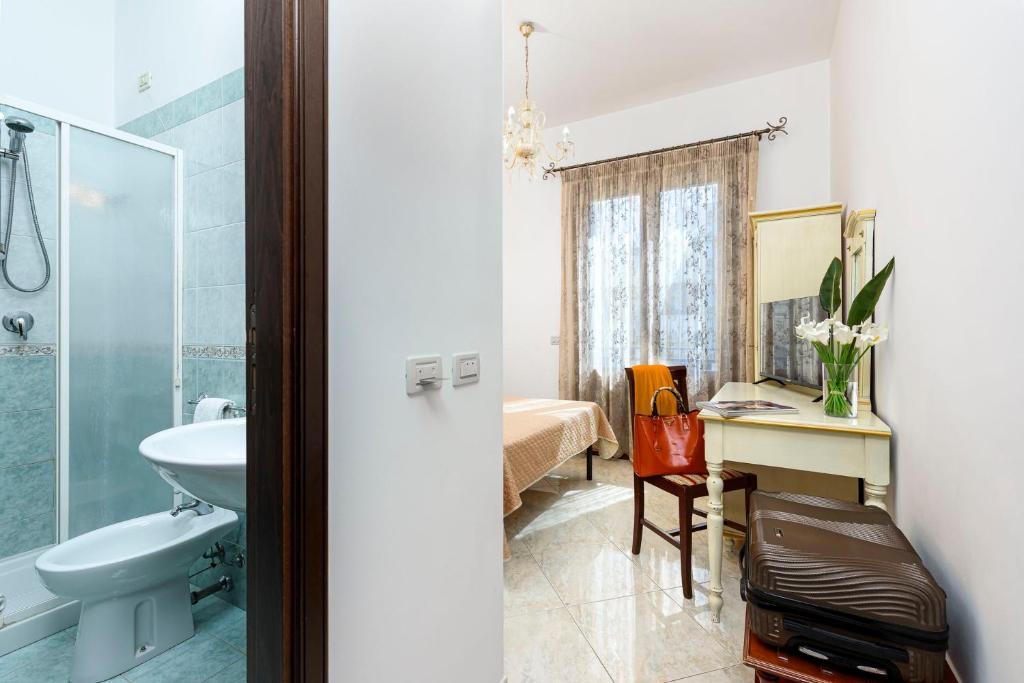 une salle de bain avec un lavabo et des toilettes et un bureau dans l'établissement Araba Fenice Hotel, à San Vito Lo Capo