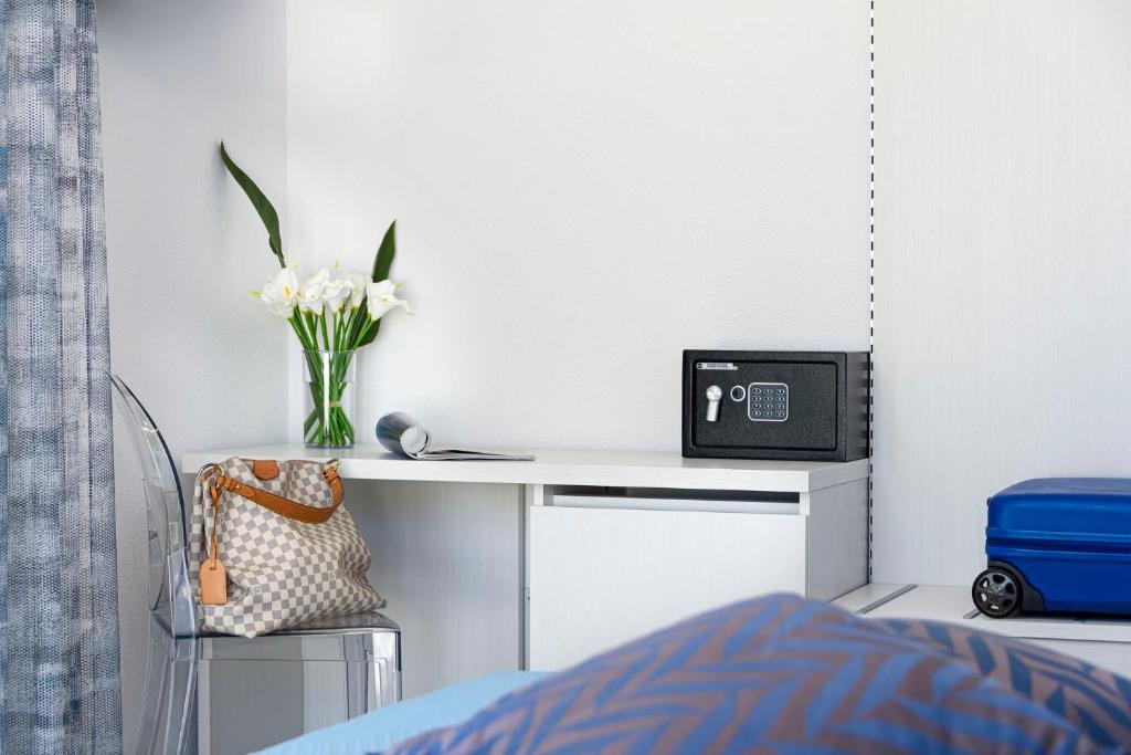 une chambre avec un bureau avec une télévision et un vase de fleurs dans l'établissement Araba Fenice Hotel, à San Vito Lo Capo