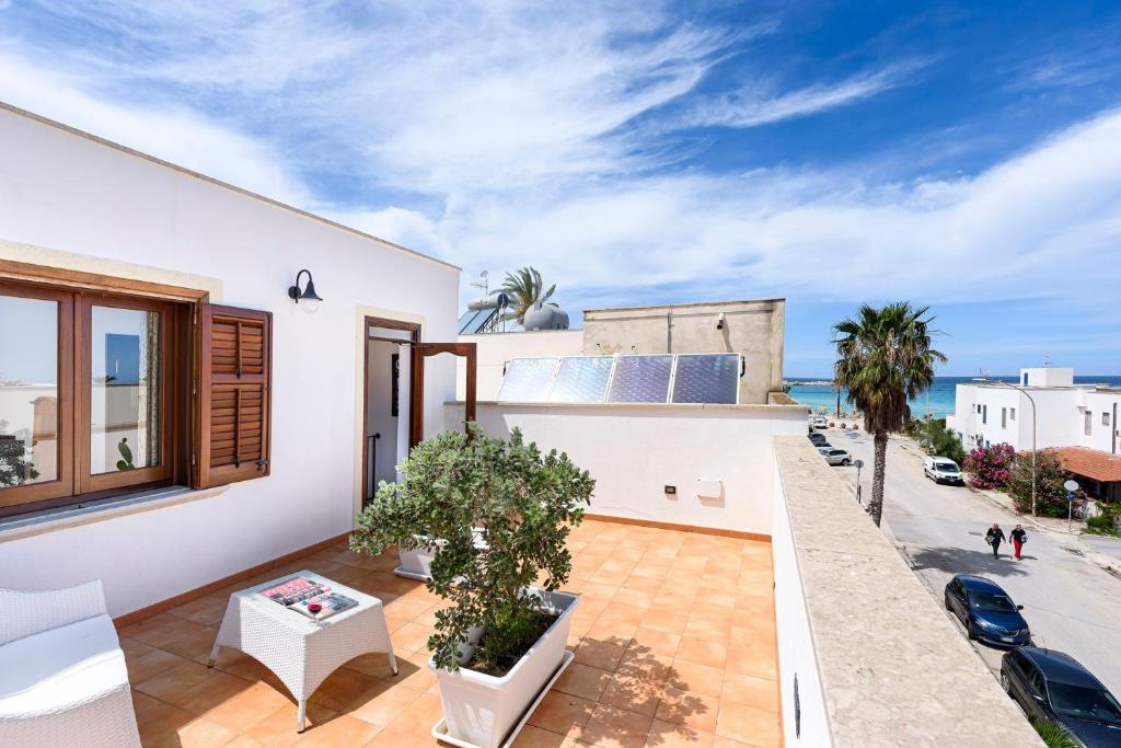une maison avec un balcon avec vue sur l'océan dans l'établissement Araba Fenice Hotel, à San Vito Lo Capo
