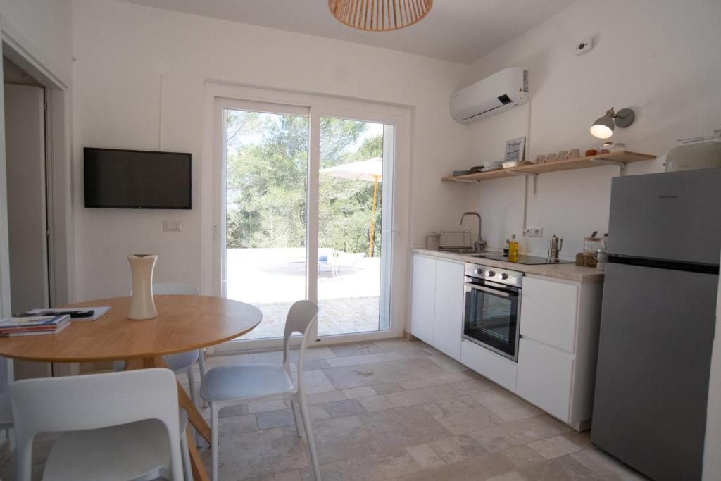 Il dispose d'une cuisine avec une table et d'une salle à manger avec un réfrigérateur. dans l'établissement Puglia Essence - Ancient Lamia & Exclusive Pool, à Martina Franca
