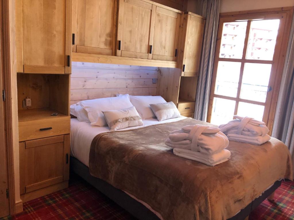 une chambre avec un lit avec deux serviettes dessus dans l'établissement Appartement T3 ARC 1950 skis aux pieds Sauna, Hammam, Jacuzzi, à Arc 1950