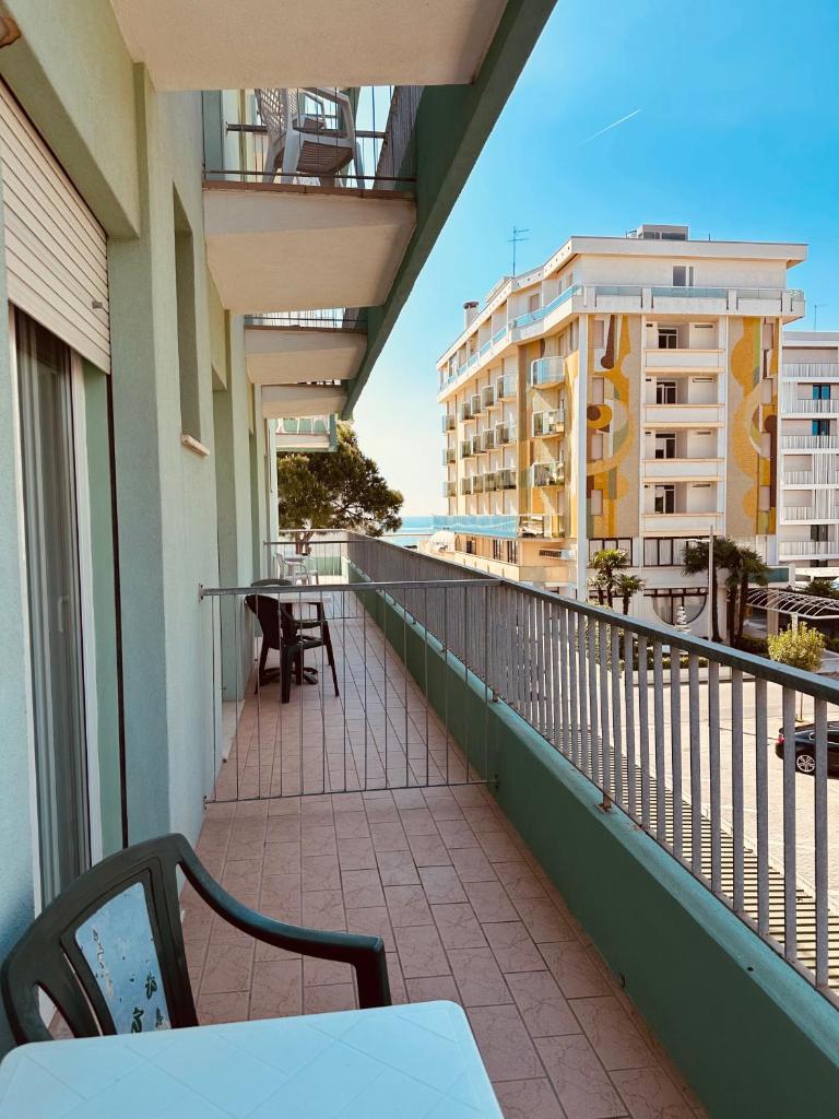 un balcon avec une table et des chaises sur un immeuble dans l'établissement Hotel Palme Park & Beach included, à Lido di Jesolo