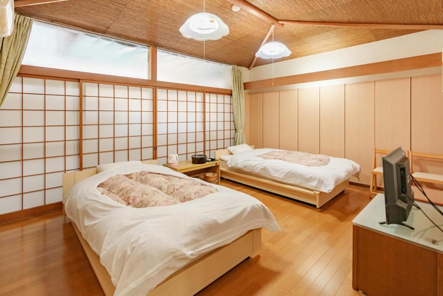 - une chambre avec 2 lits et une télévision dans l'établissement 熱海来宮の湯 松月, à Atami