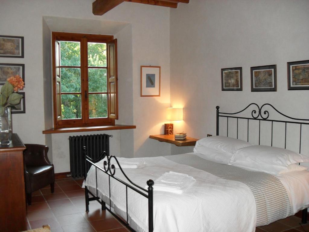 une chambre avec un grand lit et une fenêtre dans l'établissement Villa Montignoso, à Castagno 111 autres photos